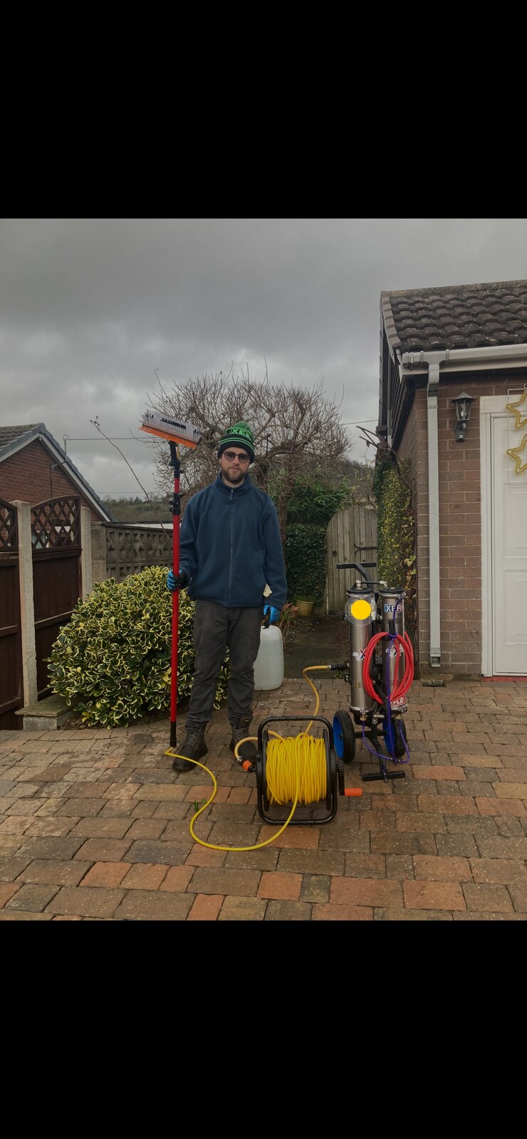 Natecleans technician with water-fed pole and purification system